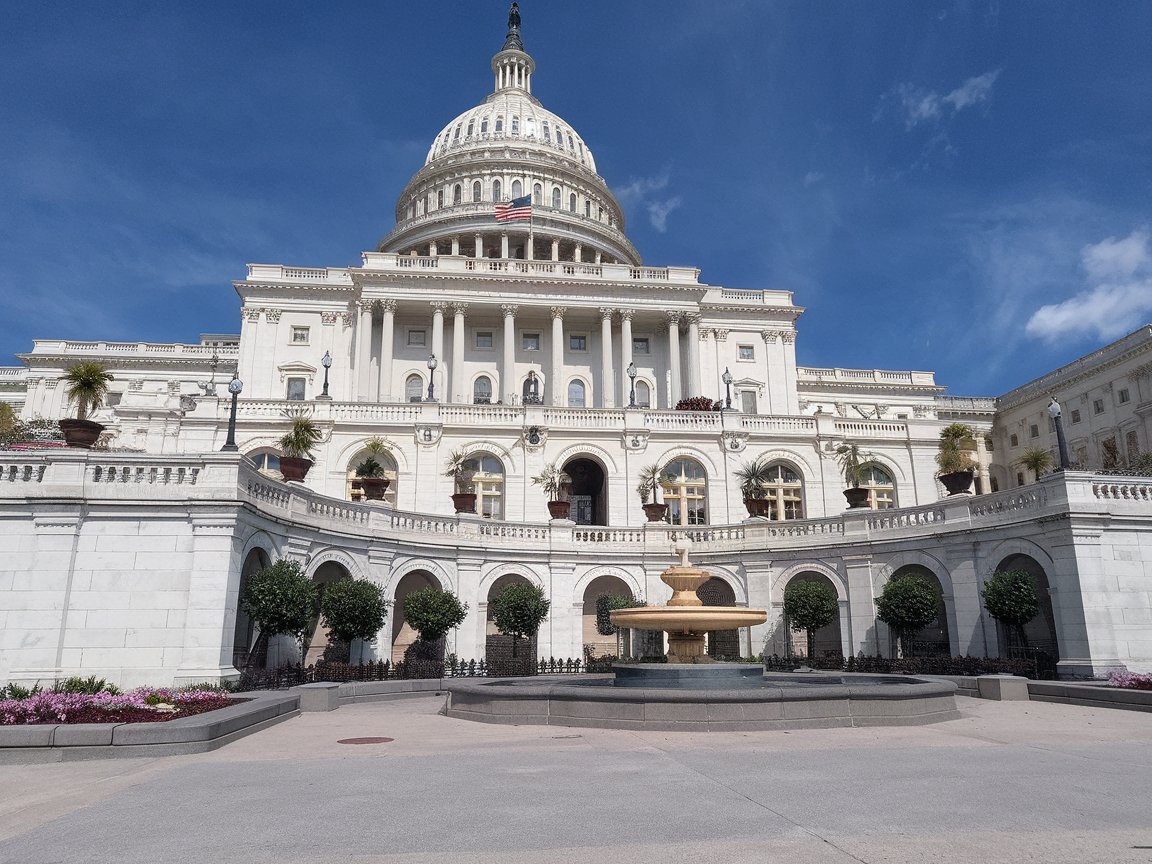 A majestic view of the U.S. Capitol Building in Washington, D.C., with its iconic dome and beautifully landscaped grounds.