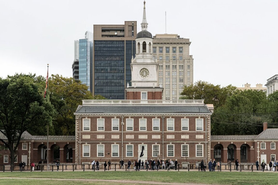 A view of Independence Hall in Philadelphia, surrounded by vibrant greenery and visitors exploring the historic site.