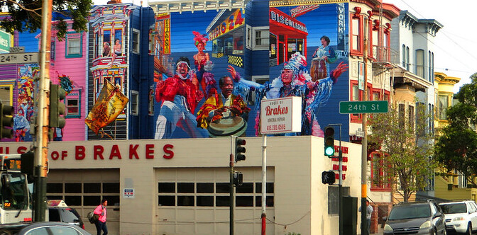 A vibrant street in the Mission District, San Francisco, adorned with colorful murals and lined with trendy cafes and shops