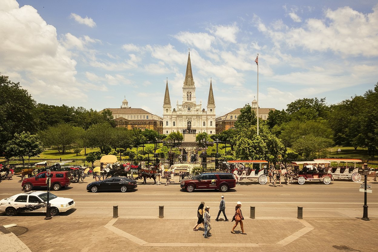 A lively scene in New Orleans’ French Quarter, featuring jazz musicians performing on the street and colorful buildings with wrought-iron balconies.